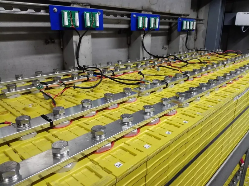 Banco di celle LFP da 700 Ah collegate in serie e in parallelo con barre, con le schede del sistema di gestione (BMS) sopra di esse.